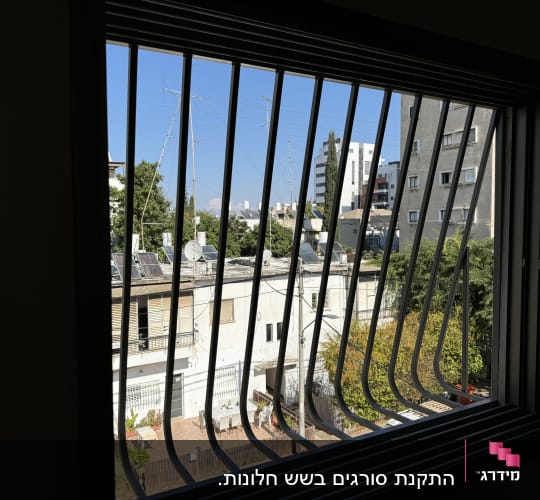 חלון עם סורגים מתכתיים נראים מבחוץ